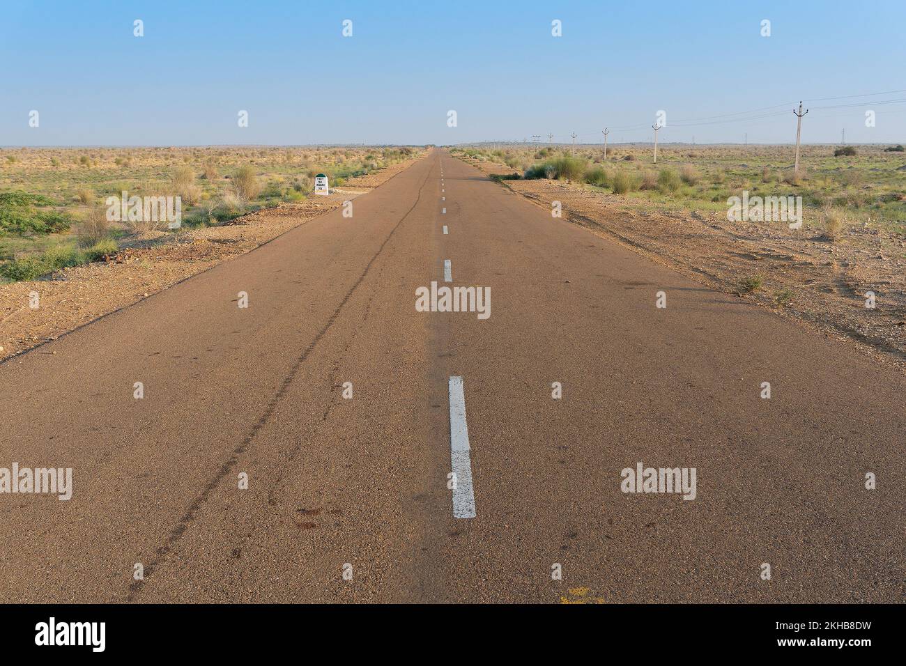 Matin dans le désert avec une route vide ou une route nationale en haut passant par le désert. Horizon lointain, été chaud au désert de Thar, Rajasthan, Inde. Banque D'Images