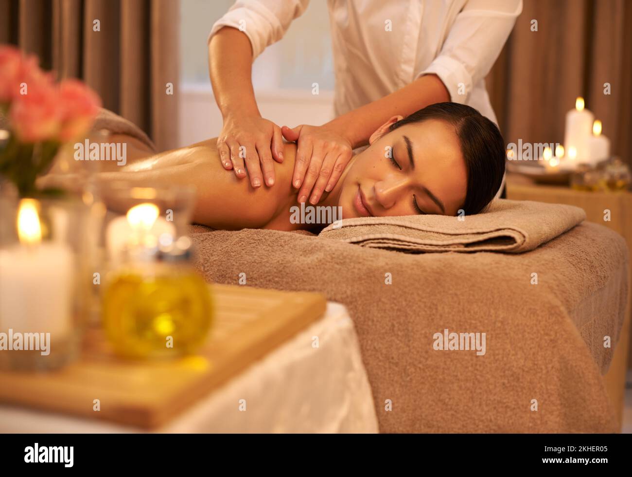 Travailler des miracles avec ses mains. Une belle jeune femme qui profite d'un massage au spa. Banque D'Images