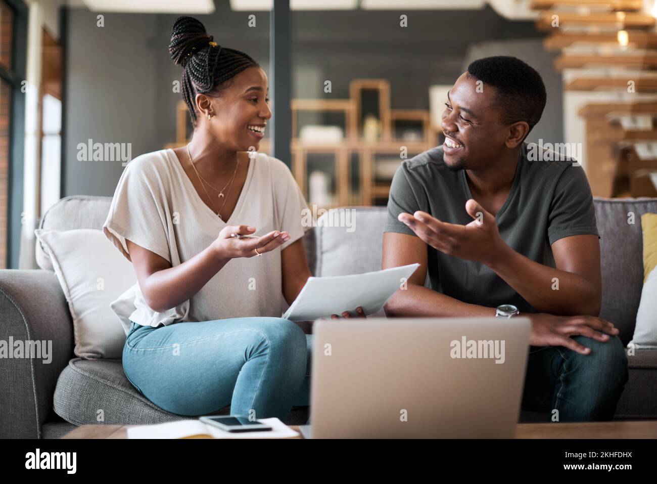 Couple noir, documents fiscaux et factures sur le canapé du salon à la maison avec ordinateur portable, documents financiers et économies de planification. Les finances familiales Banque D'Images