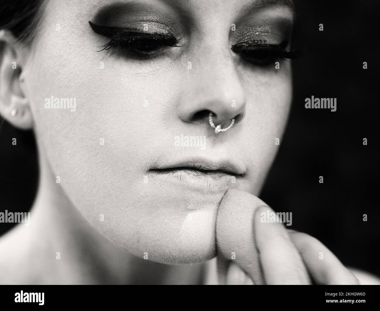 une femme avec un anneau de nez applique le maquillage à son visage Banque D'Images