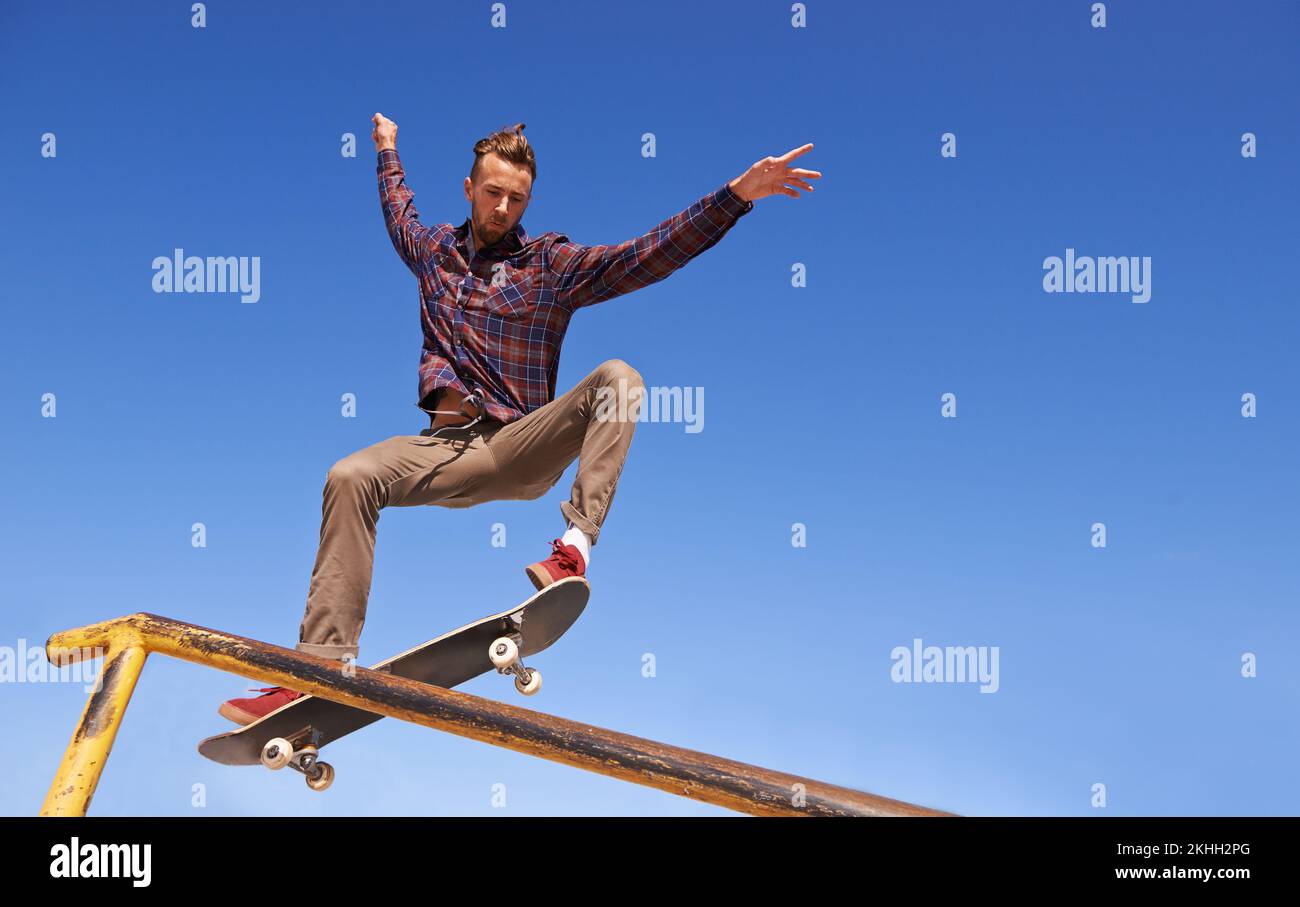 Comme un pro. un skateboarder effectuant un tour sur un rail. Banque D'Images