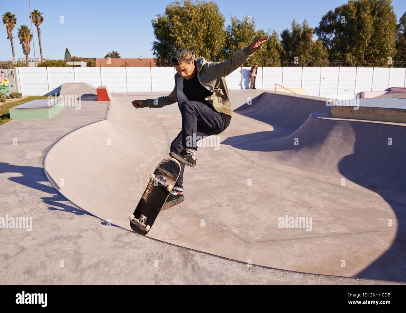 Découvrez-LE. Un jeune homme qui fait des tours sur son skateboard au skate Park. Banque D'Images