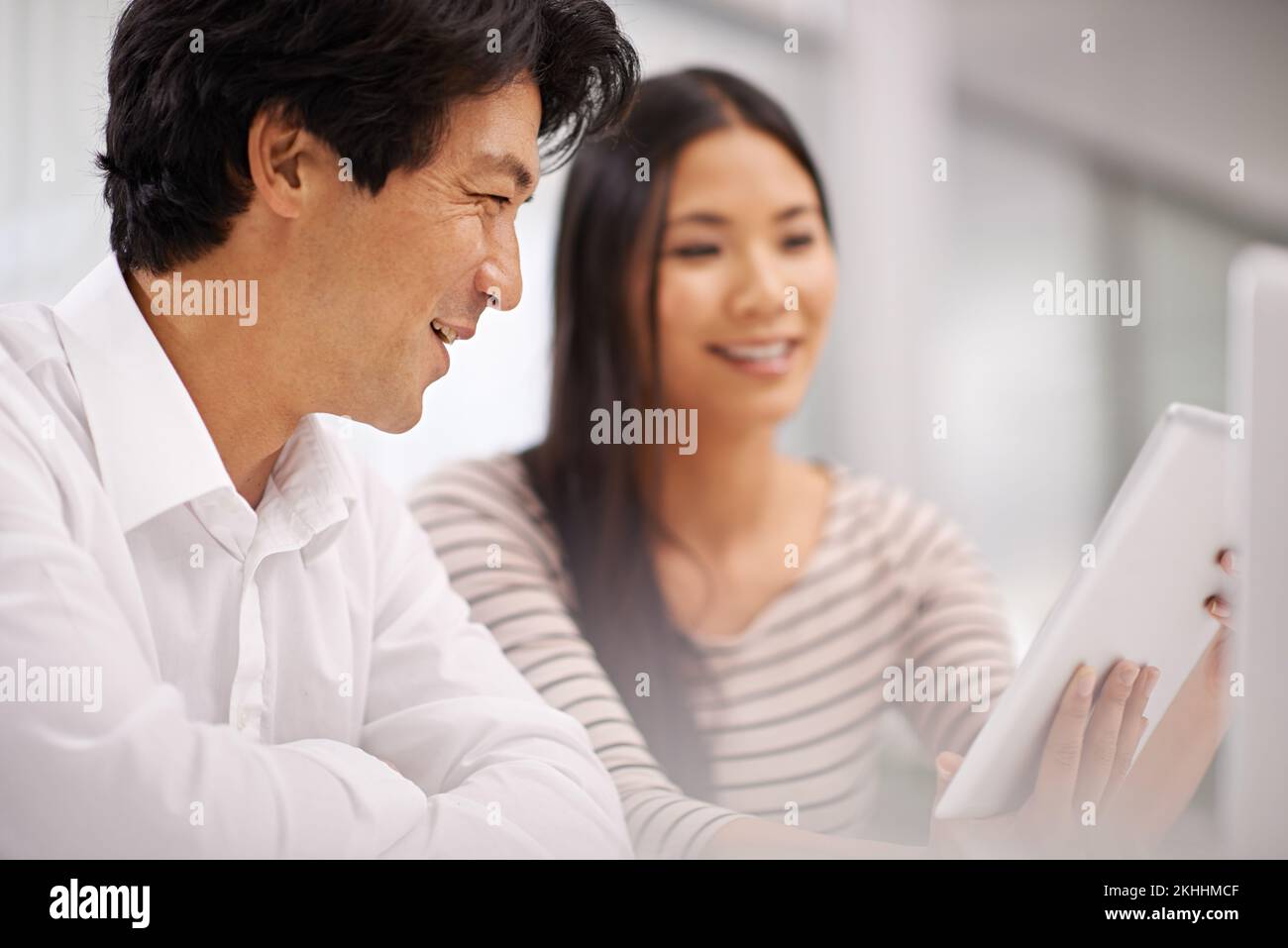 Ils ont reçu toutes les informations dont ils ont besoin. deux collègues professionnels discutent du travail sur une tablette. Banque D'Images