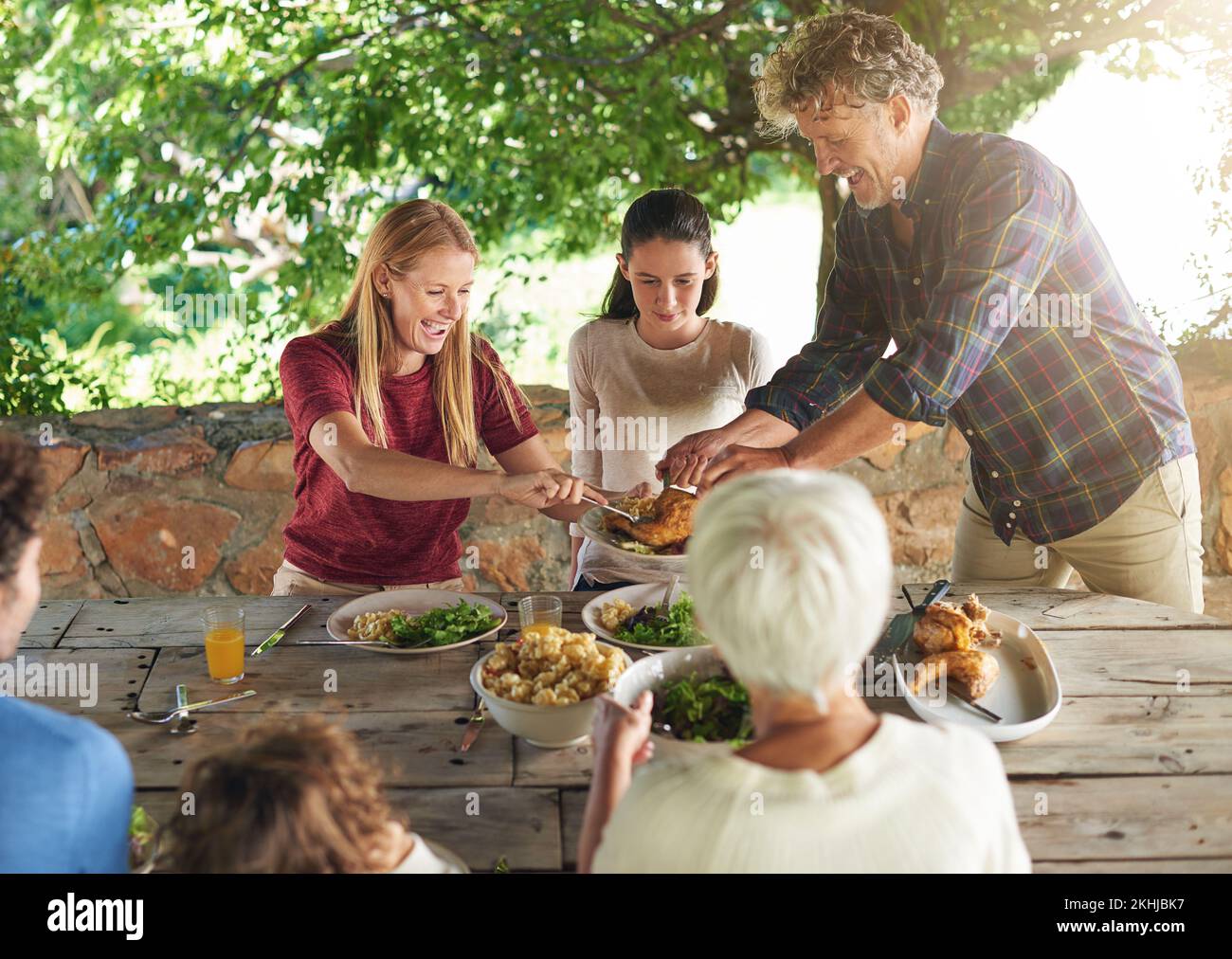 Theres plus que suffisant pour tout le monde. une famille se préparant à déjeuner ensemble à l'extérieur. Banque D'Images