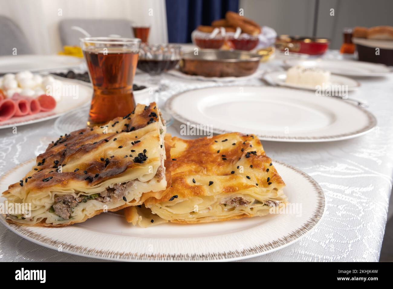 Photo en gros plan de la patty turque appelée su borek avec de la viande. Table de petit-déjeuner traditionnelle avec thé en verre. Idée du concept délicieux déjeuner du matin. Banque D'Images