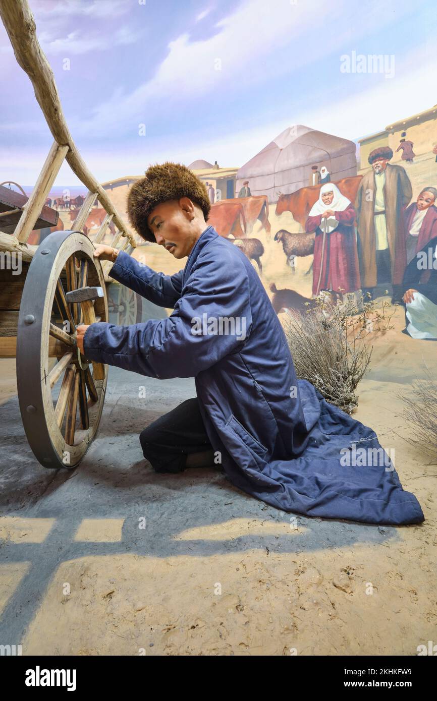 Un diorama d'une époque de la route de la soie famille kazakh, détail du père réparant une roue de chariot. Au Musée des victimes de la répression politique à Kar Banque D'Images