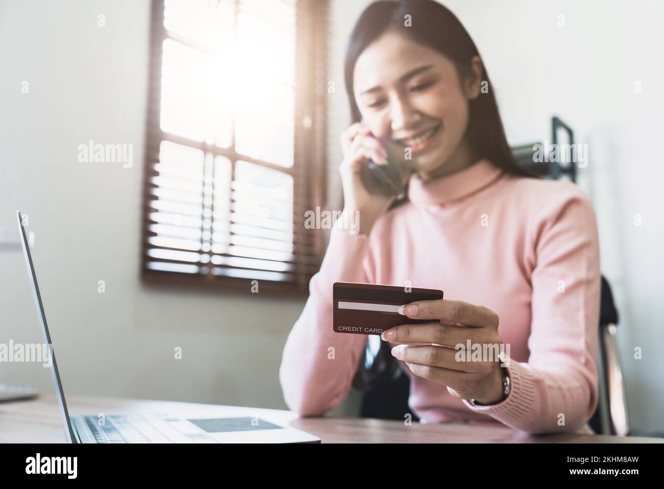 Femme tenant une carte de crédit et de confirmer l'achat par téléphone au service à la clientèle, souriant asiatique fille qui fait le paiement par la conversation de smartphone Banque D'Images