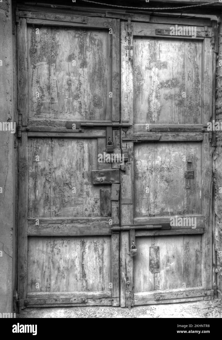 Une échelle de gris verticale d'une porte en bois pourri d'une maison traditionnelle égyptienne Banque D'Images