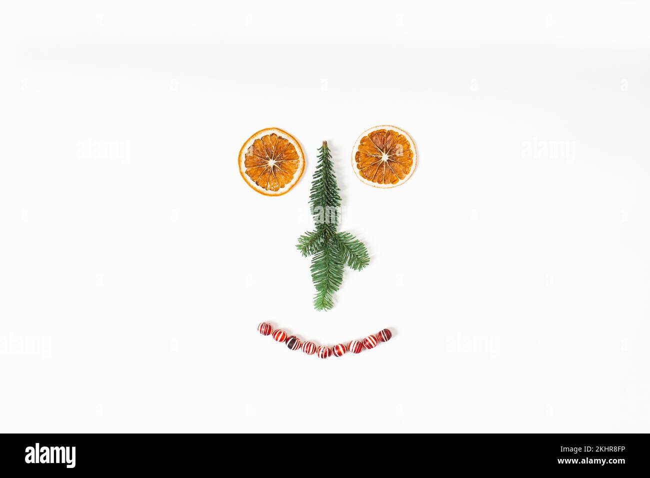 Drôle visage de décorations de Noël avec orange sec, sapin et bonbons sur blanc Banque D'Images