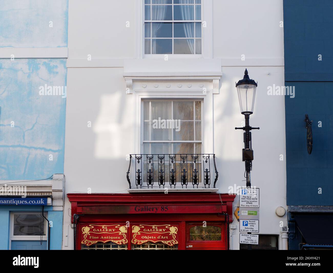 Bâtiment blanc avec balcon et bâtiments bleus de part et d'autre au-dessus des boutiques sur Portabello Road dans le quartier de Notting Hill à Londres Banque D'Images