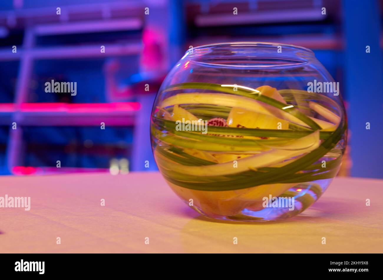 Fleur d'orchidée dans l'eau dans un vase en verre sur une table sur un fond coloré Banque D'Images