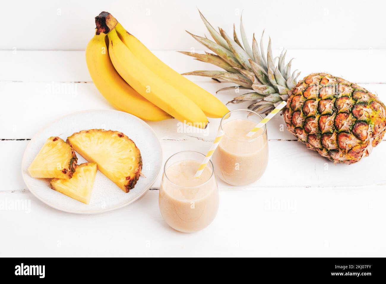 Smoothie à la banane et à l'ananas sur une table en bois blanc avec ingrédients. Detox concept de régime, boisson de vitamine d'été. Vue de dessus Banque D'Images
