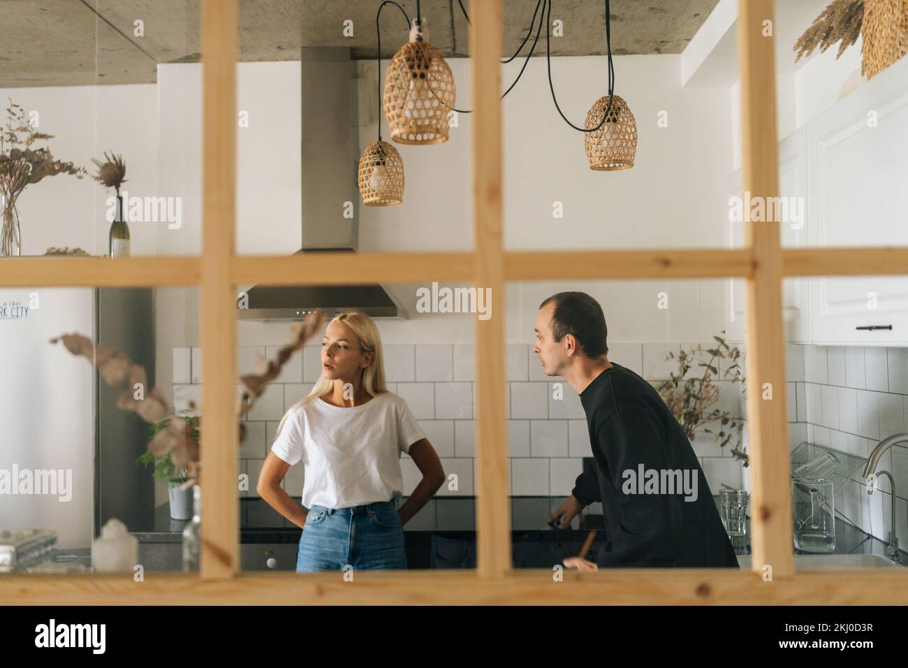 Vue à distance de mari en colère collant, élevant la voix, criant à ignorer la jeune femme petite amie debout dans la salle de cuisine. Concept de problèmes familiaux. Banque D'Images