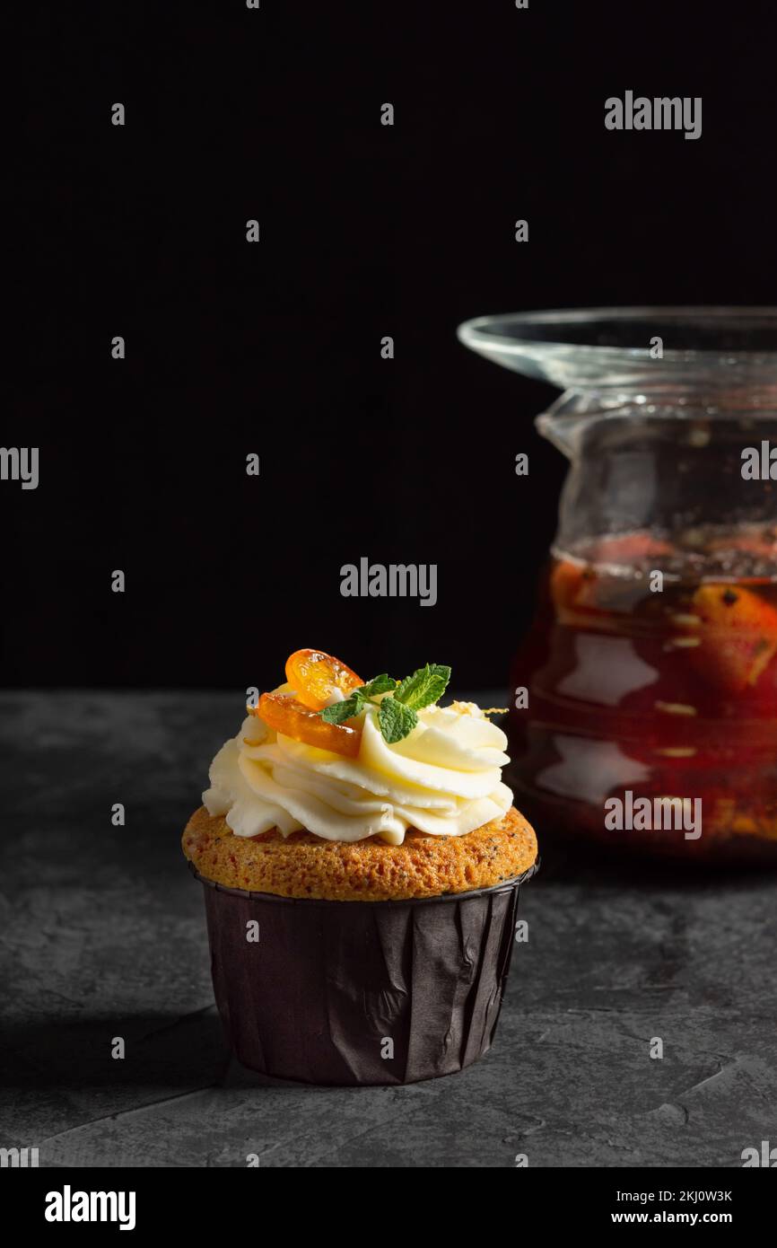 Cupcakes à la crème au fromage, décorés de baies sucrées sur fond sombre Banque D'Images