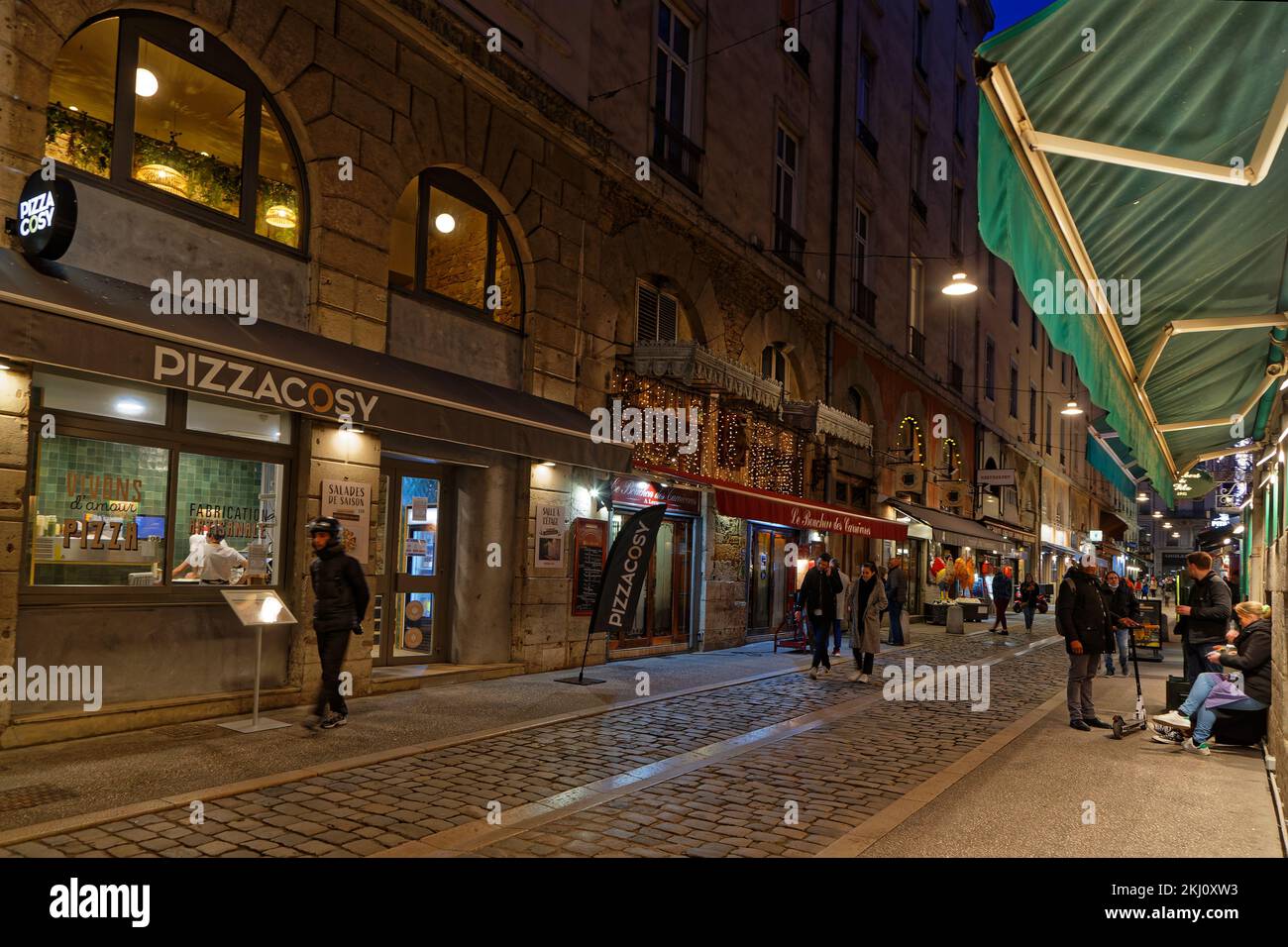 LYON, FRANCE, 19 février 2022 : rue touristique avec plusieurs petits restaurants, appelés un bouchon, qui servent une cuisine lyonnaise traditionnelle en convi Banque D'Images