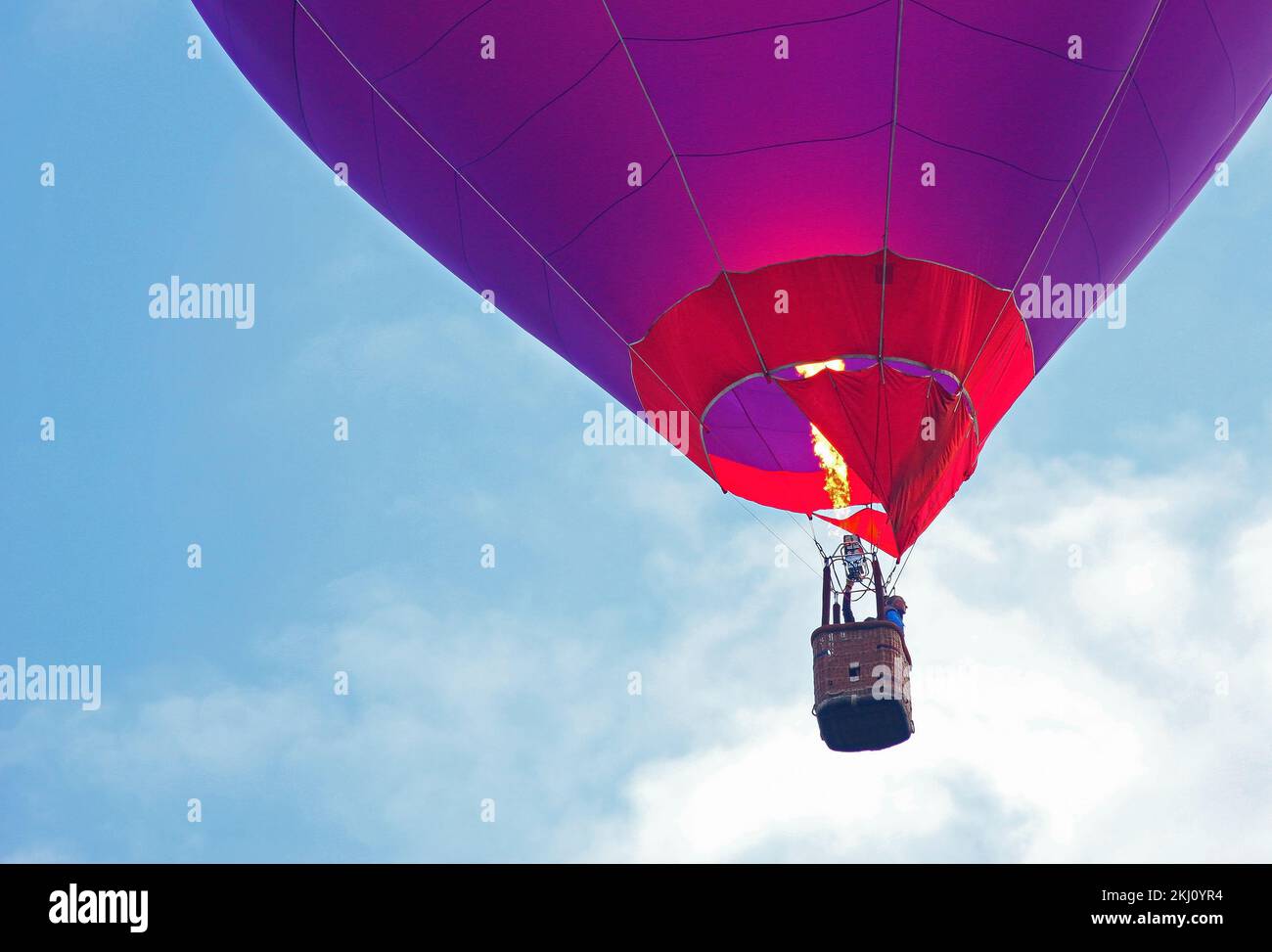 Panier ballon d'air chaud en gros plan. Flamme jaune, personne dans le panier. Banque D'Images