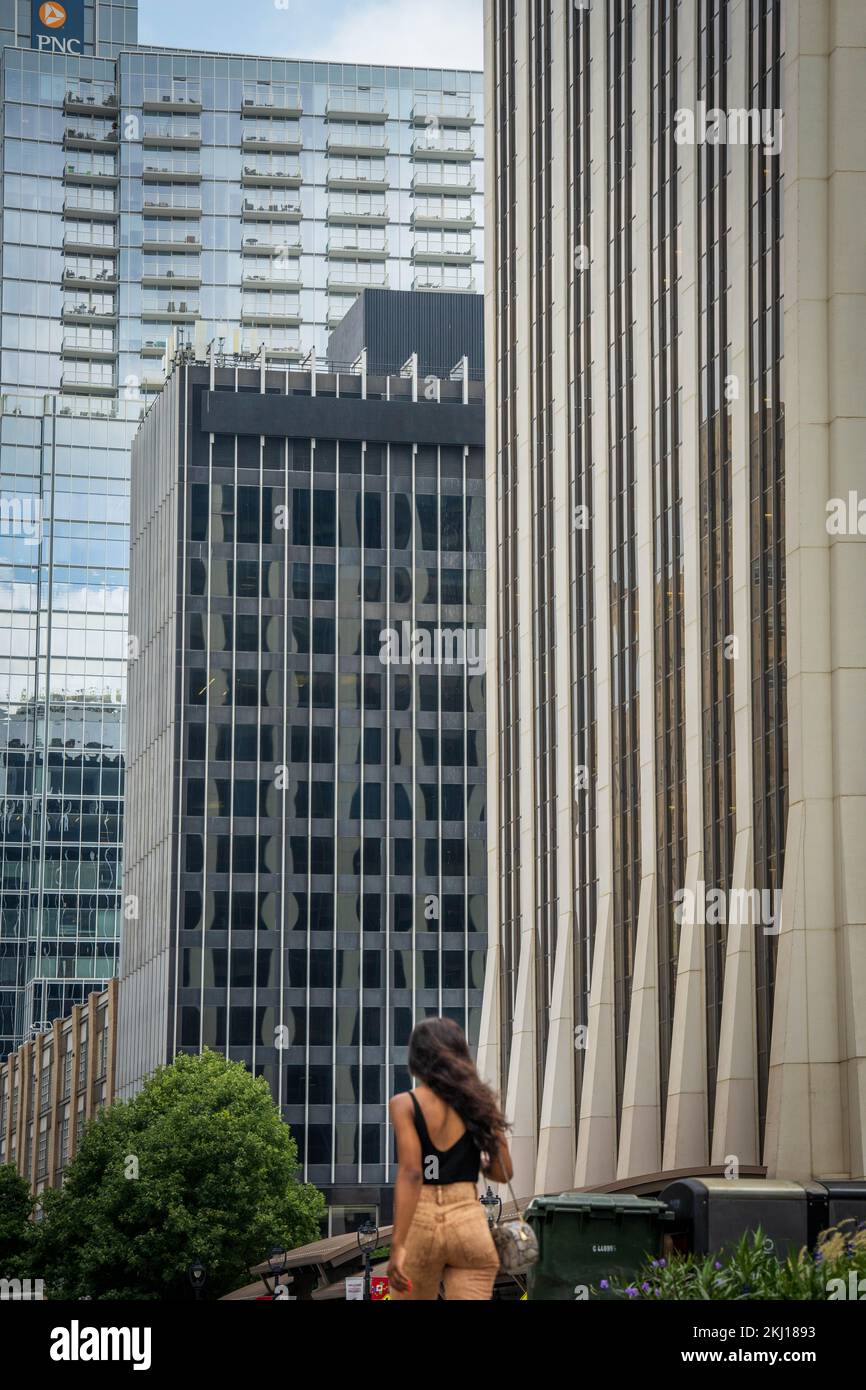une jeune femme passe devant de hauts bureaux Banque D'Images
