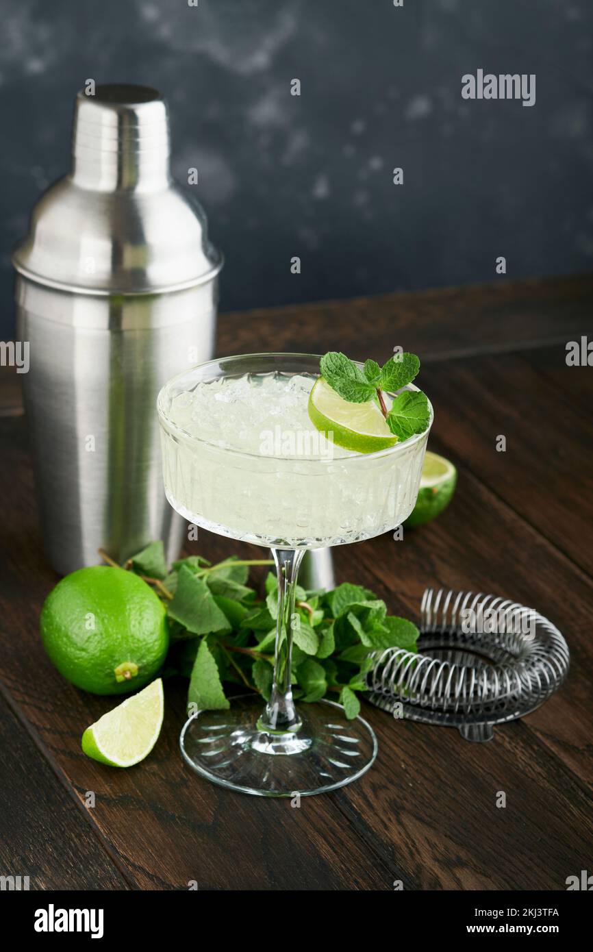 Cocktail de Margarita avec citron vert, tequila, menthe et glace sur table sombre avec rétroéclairage incroyable, espace de copie. Margarita classique ou cocktail Daiquiry. Carte à barres Banque D'Images