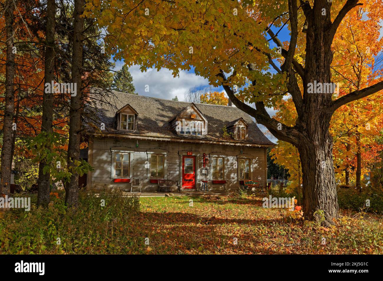 BAIE-SAINT-PAUL , CANADA, 10 octobre 2022 ; petite maison traditionnelle aux couleurs automnales de son jardin Banque D'Images