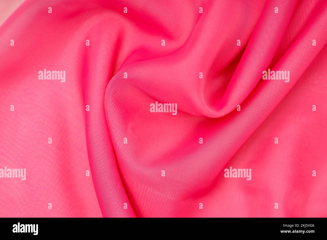 soie rose. tissu ondulé. arrière-plan abstrait pour le design. Photo de haute qualité Banque D'Images