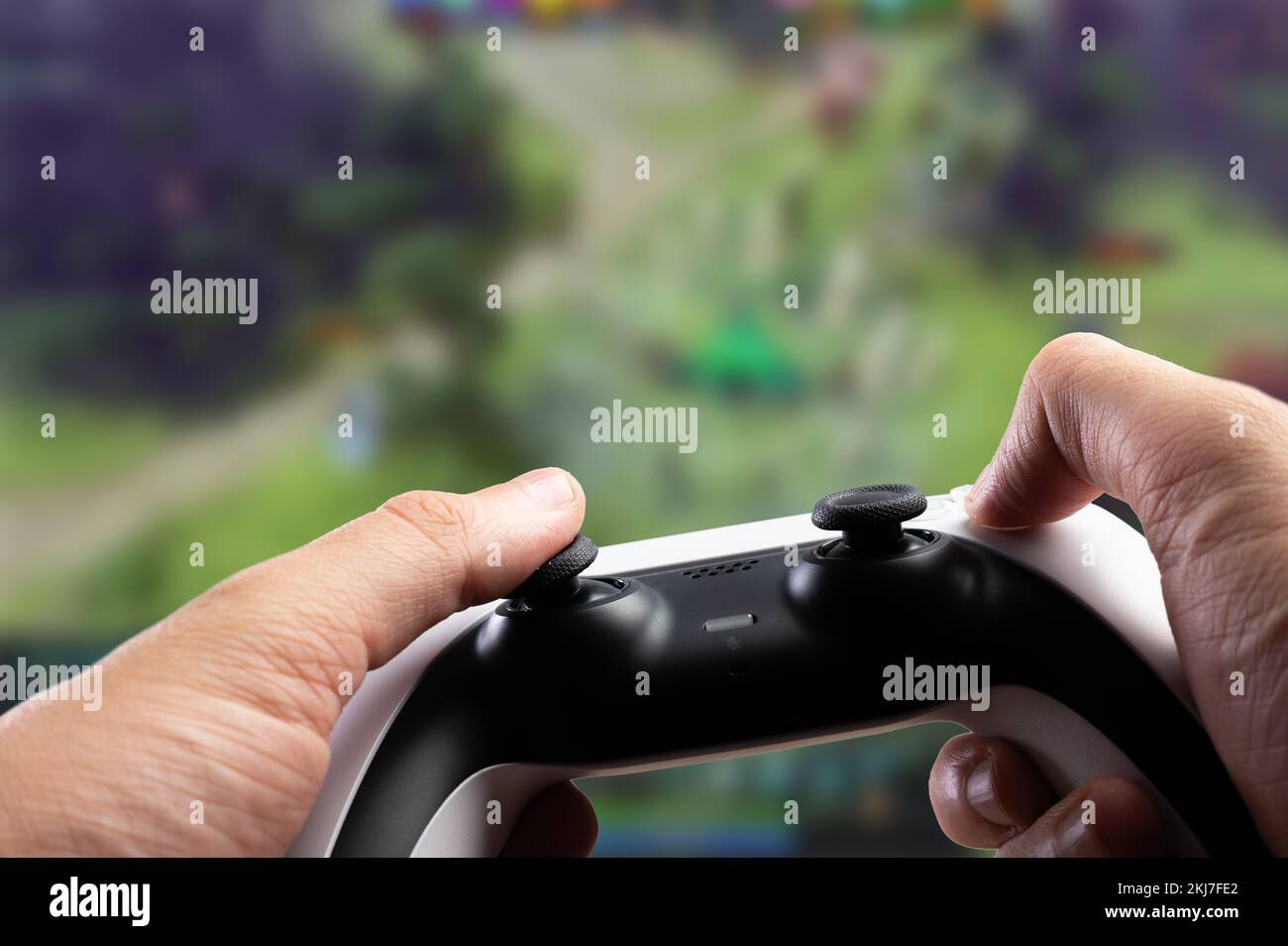 Un joueur avec un joystick dans ses mains joue un jeu vidéo d'aventure sur un grand écran TV, ordinateur personnel. Jeux vidéo, culture de la jeunesse, realit virtuel Banque D'Images