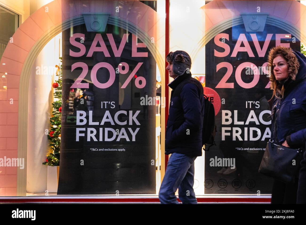 Londres, Royaume-Uni. 24th novembre 2022. Les clients se promèneront devant les vitrines des magasins de Regent et d'Oxford Street, affichant leurs panneaux de ventes du Vendredi fou et leurs réductions, prêts pour le célèbre événement de vente de demain. Credit: Imagetraceur/Alamy Live News Banque D'Images