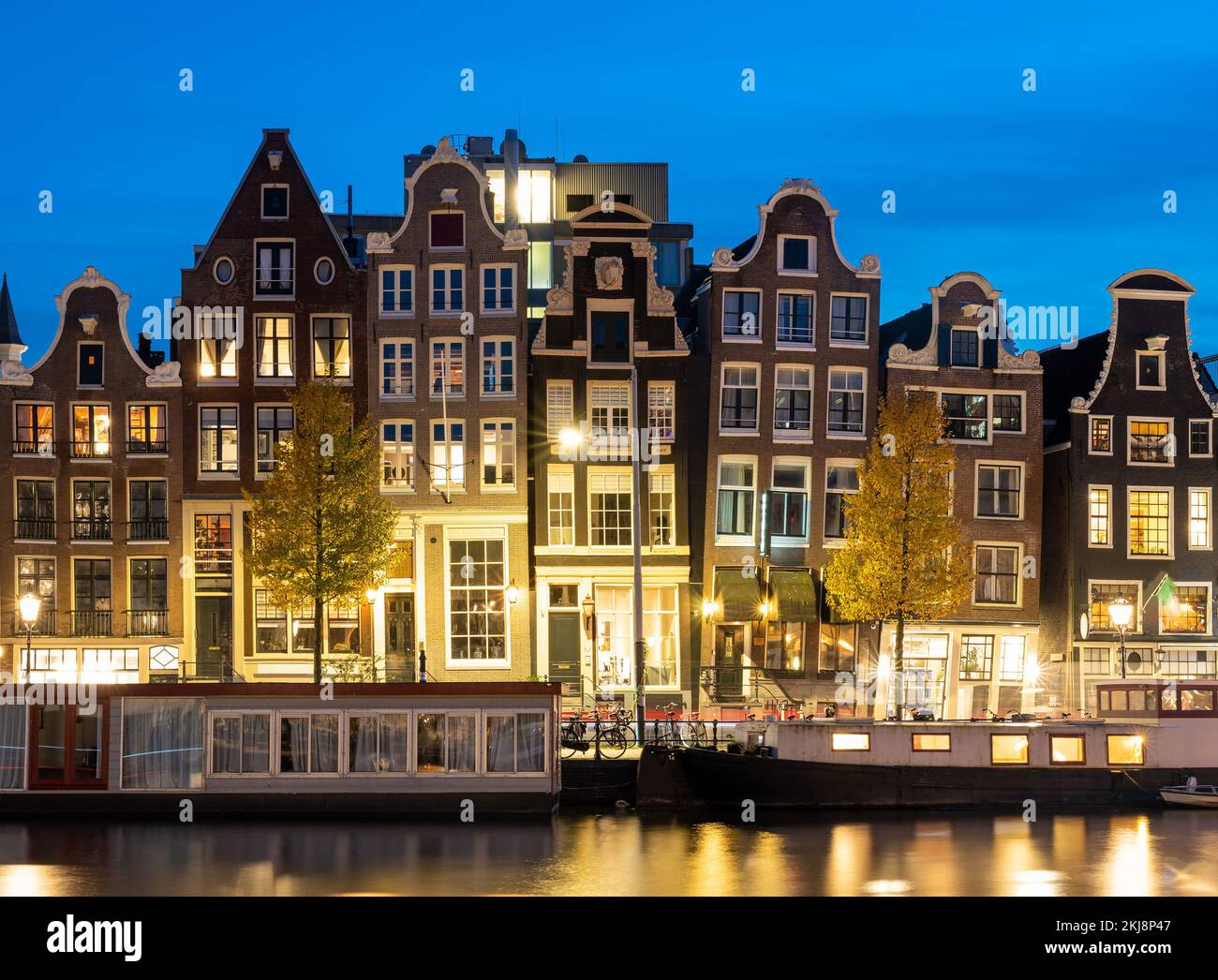 Amsterdam dans la soirée, des maisons hollandaises typiques et des bateaux à moteur le long de la rivière Amstel Banque D'Images