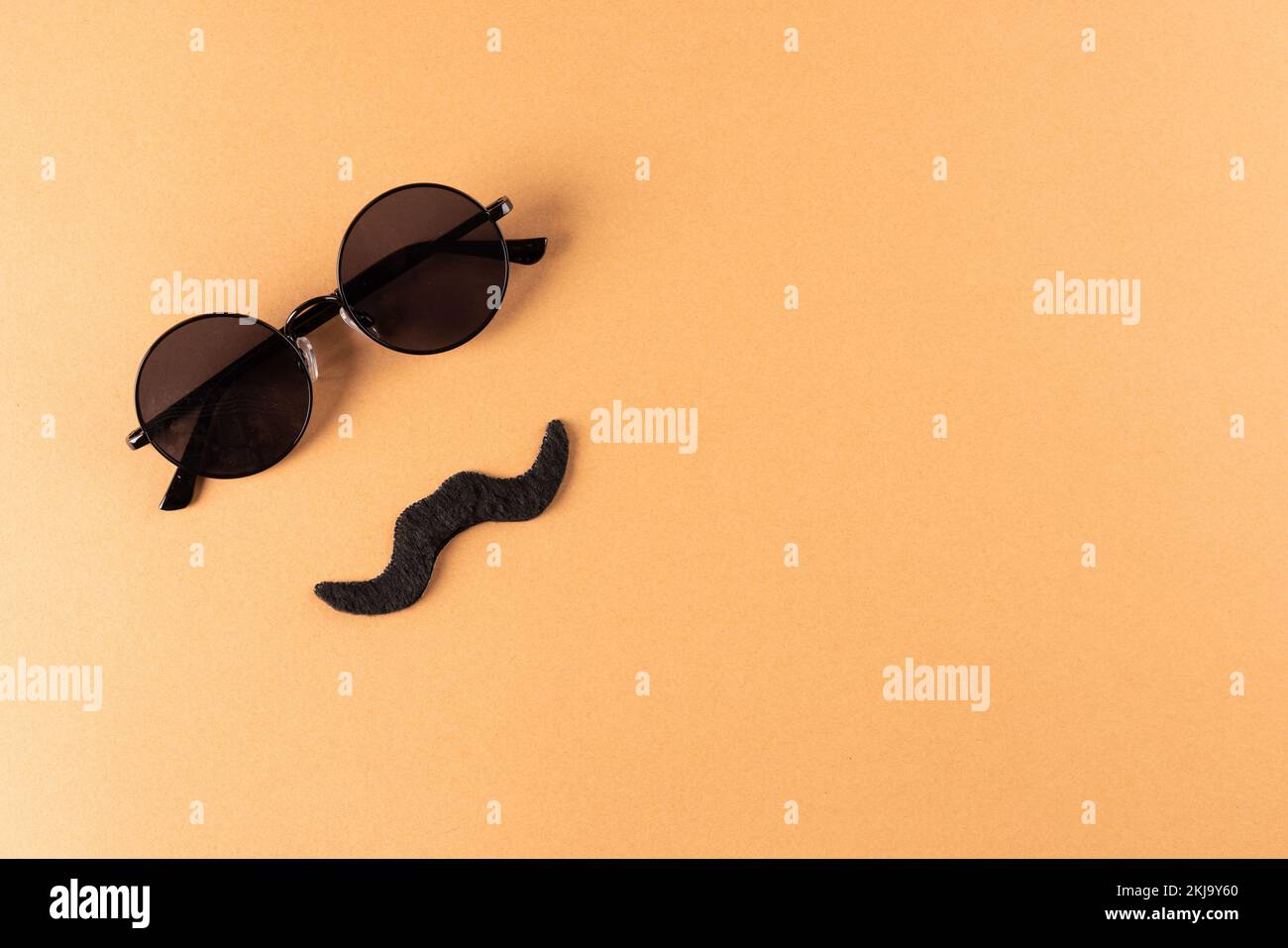 Composition de la fausse moustache et des lunettes sur fond orange avec espace de copie Banque D'Images