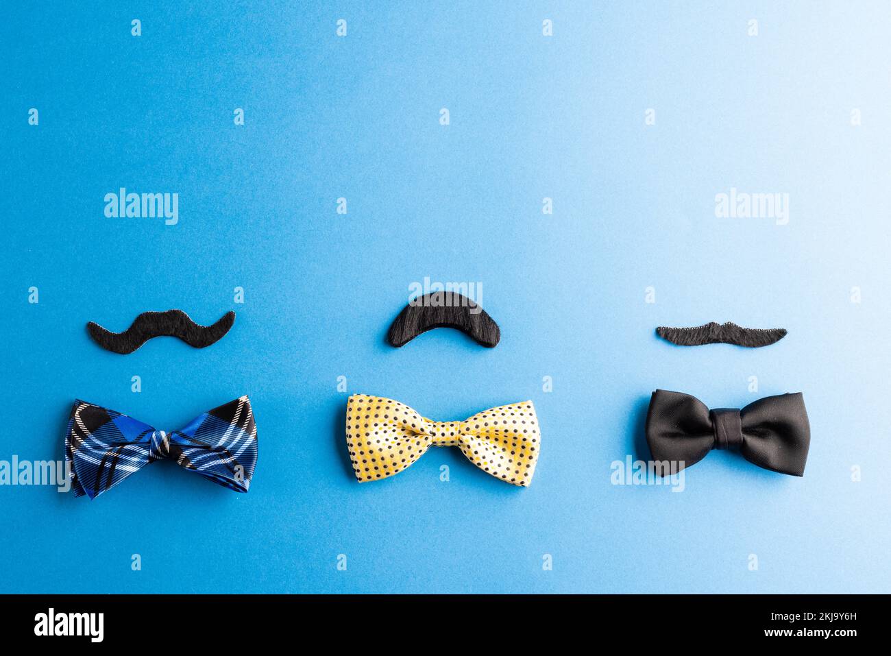 Composition de fausses moustaches et de nœuds papillon sur fond bleu avec espace de copie Banque D'Images