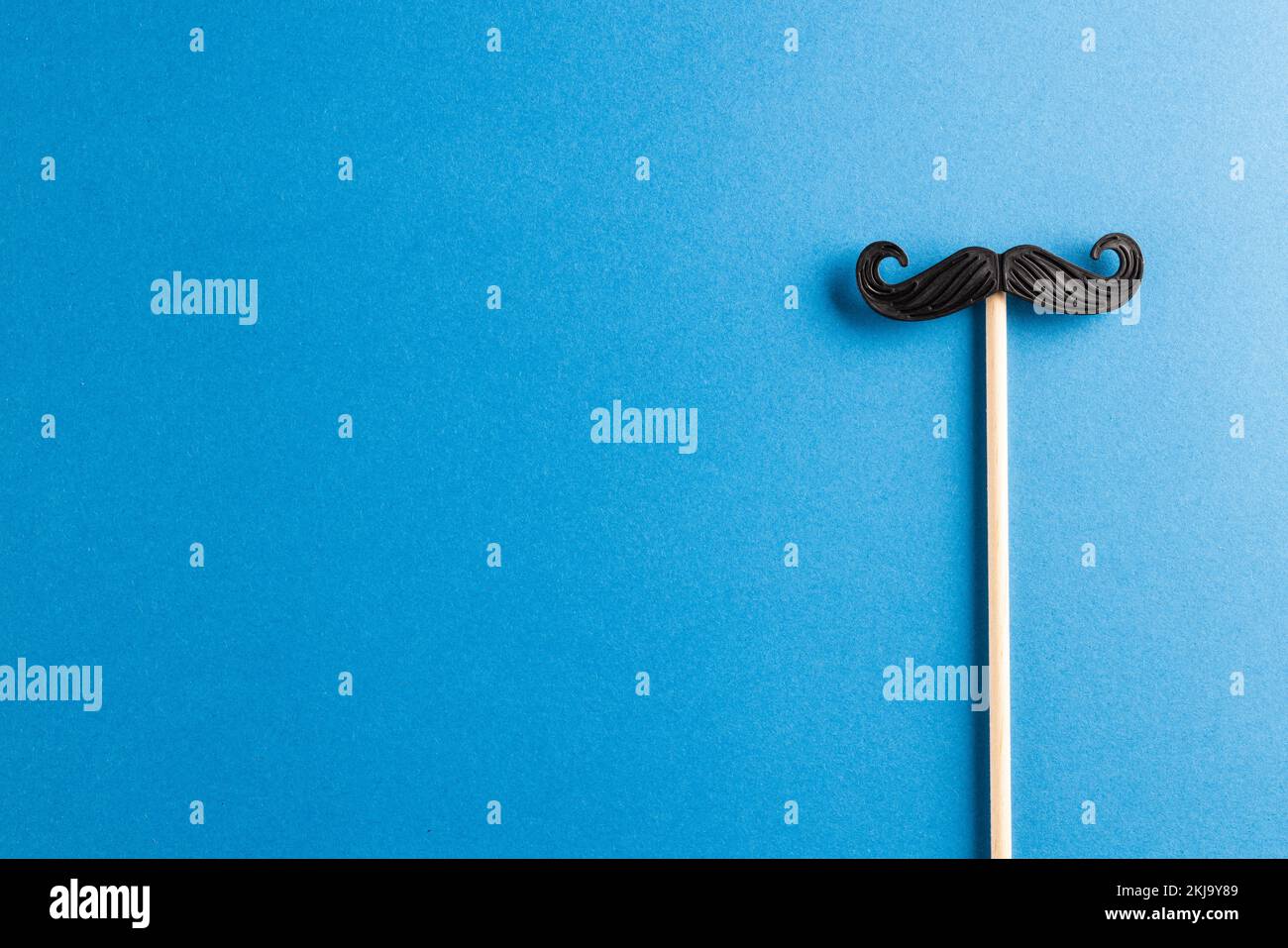 Composition de la fausse moustache sur un bâton sur fond bleu avec espace de copie Banque D'Images