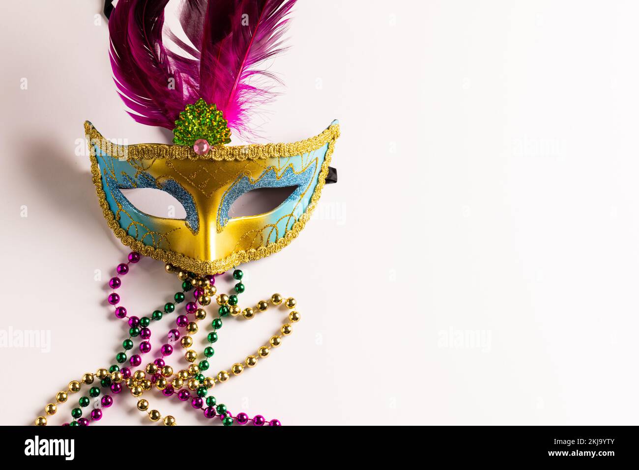 Composition de perles mardi gras colorées et masque de carnaval sur fond blanc avec espace de copie Banque D'Images