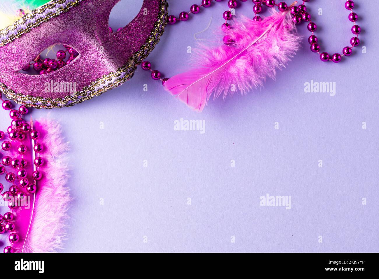 Composition de perles de gras de Mardi rose et masque de carnaval sur fond bleu avec espace de copie Banque D'Images