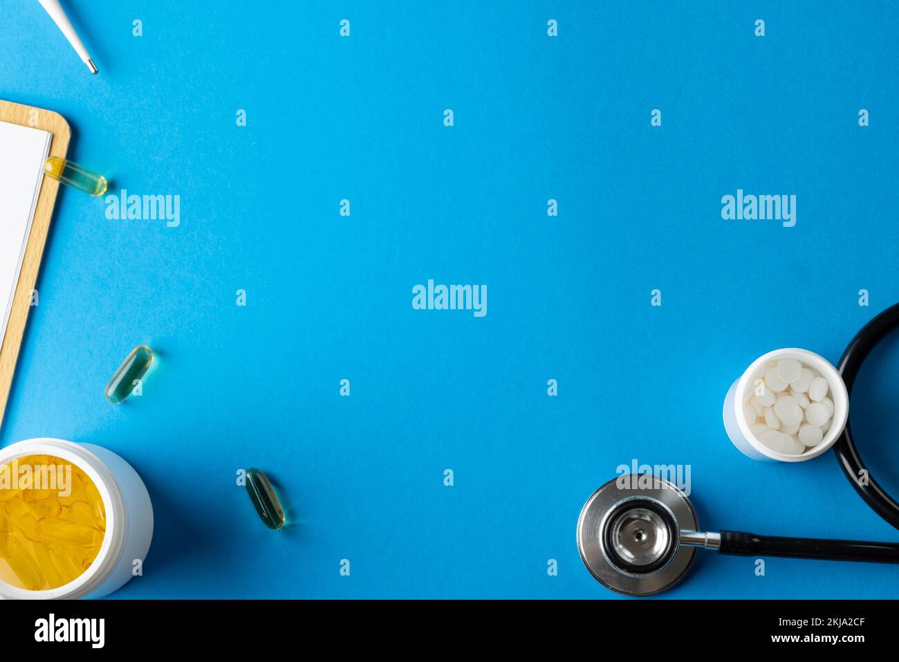 Composition du stéthoscope avec pilules et capsules sur fond bleu avec espace de copie Banque D'Images