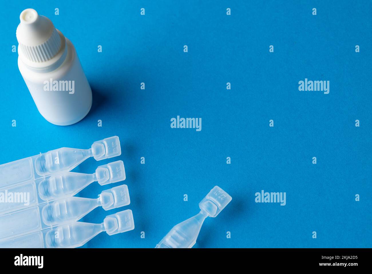 Composition des caplets de solution saline et du flacon compte-gouttes sur fond bleu avec espace de copie Banque D'Images