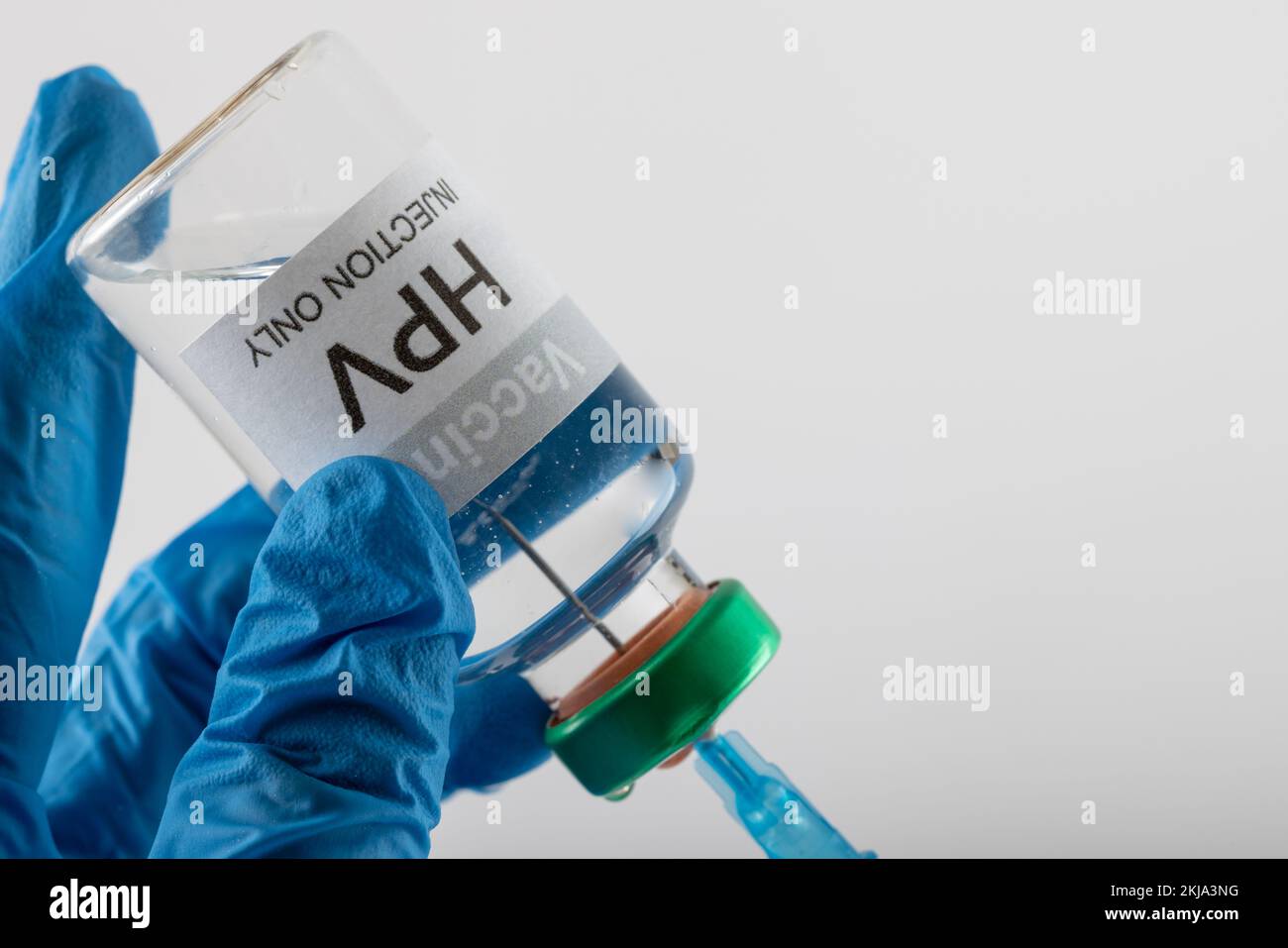 Composition de la seringue de remplissage des mains gantées du médecin à partir d'un flacon de vaccin contre le vph, sur fond blanc avec un espace de copie Banque D'Images