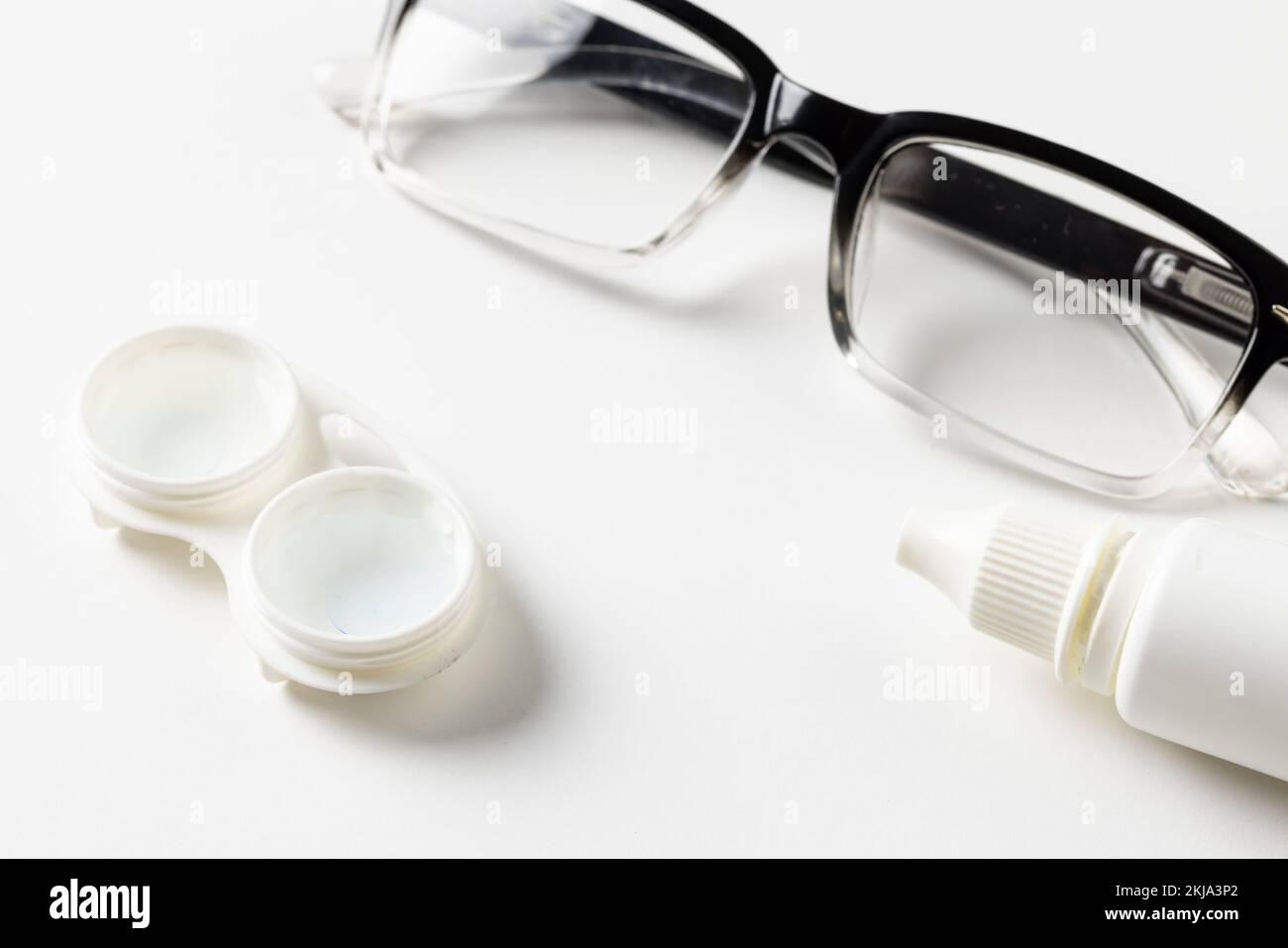 Composition de lunettes avec gouttes pour les yeux et boîtier pour lentilles de contact sur fond blanc Banque D'Images