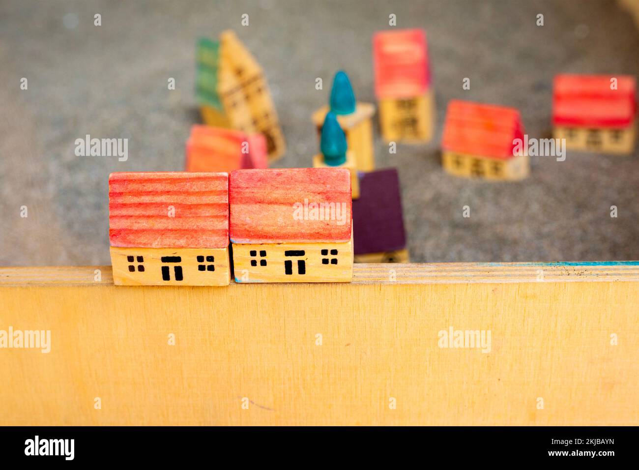 Deux petites maisons de jouets en bois à la frontière. Jeu pour enfants. Cottages avec toit rouge sur sol gris. Village de modélisation. Construction et concept architectural Banque D'Images