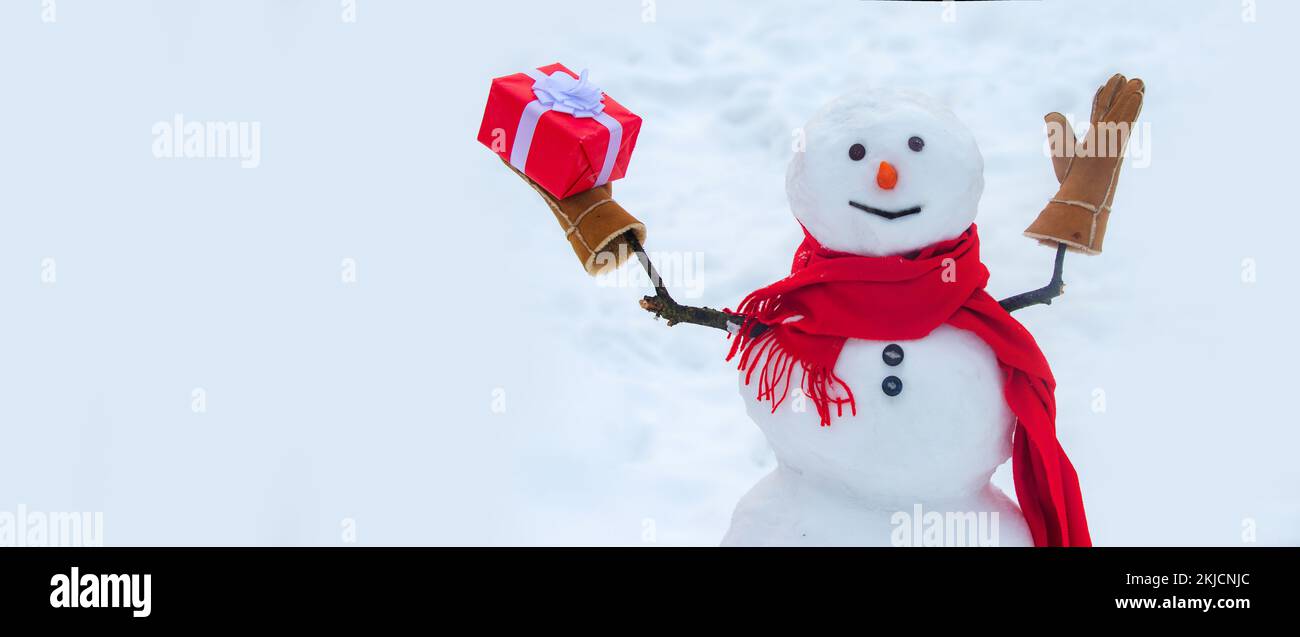 Bonhomme de neige avec cadeau de Noël. Cadeau bonhomme de neige présente concept. Cadeau bonhomme de neige. Affiche publicitaire pour les fêtes. Banque D'Images