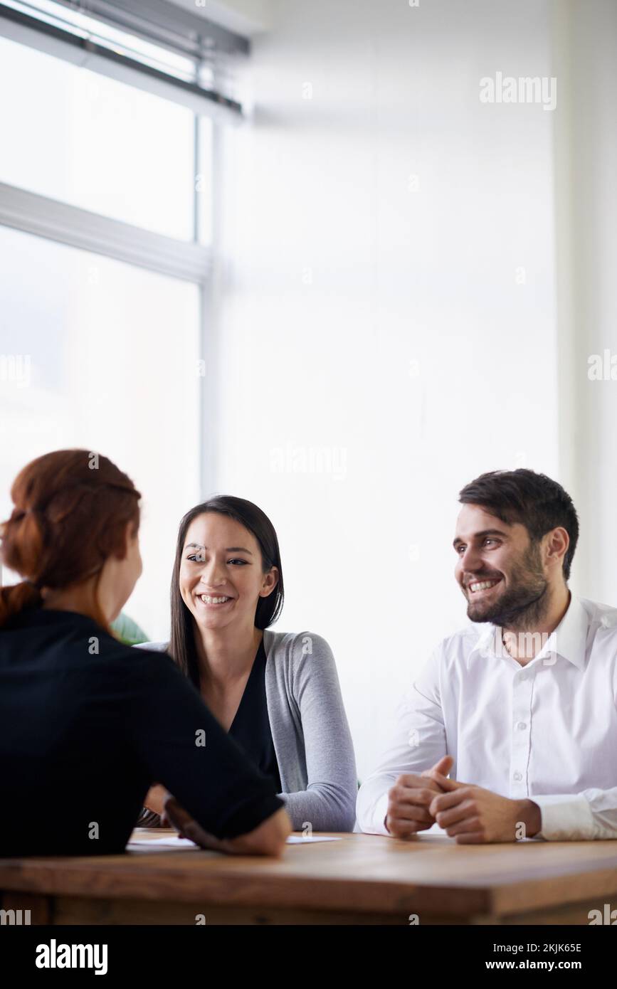 Les équipes gagnantes se font confiance. un groupe de jeunes professionnels en discussion autour d'une table. Banque D'Images