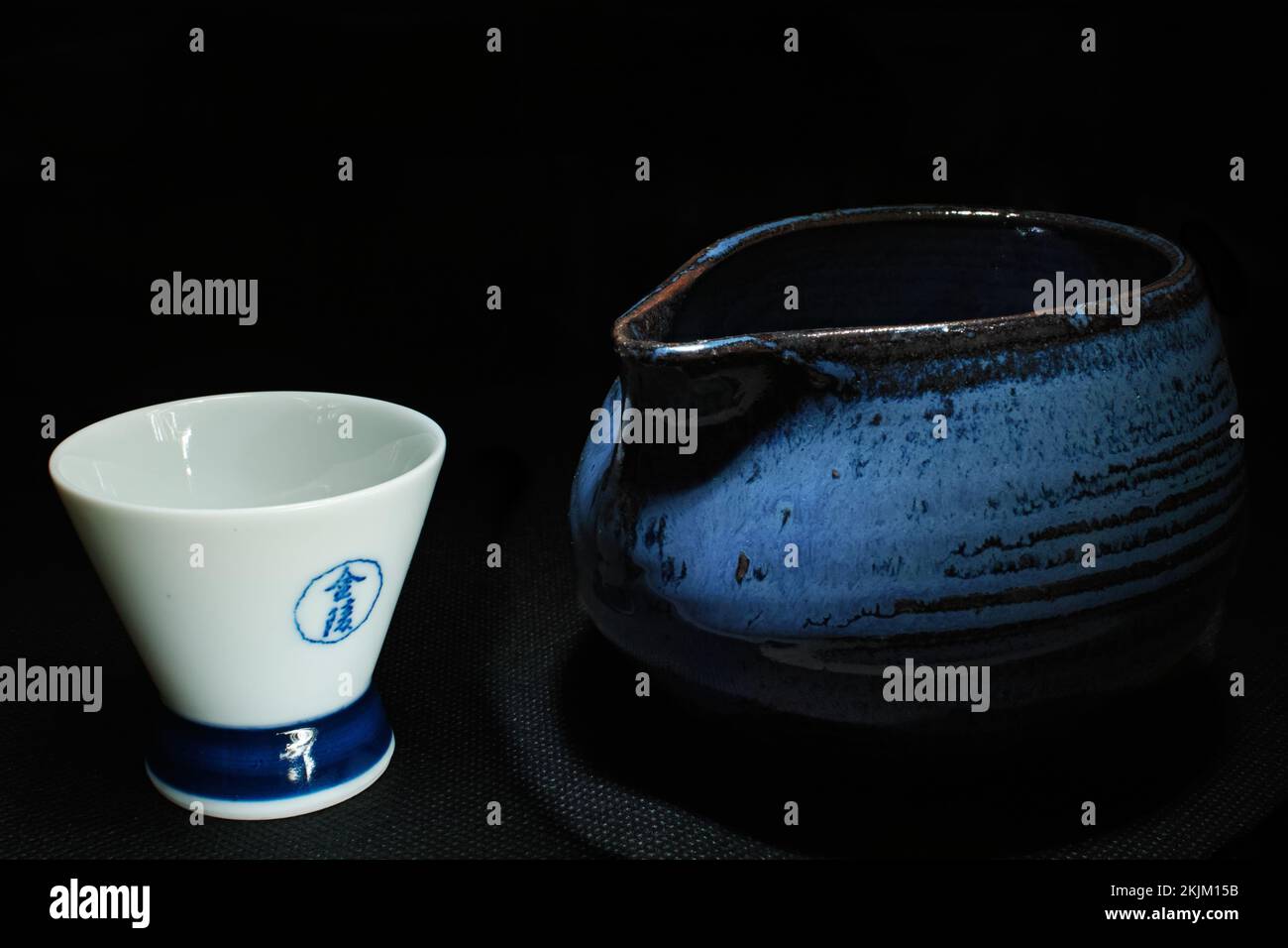 Bouteille de saké bleu japonais et tasse blanche illuminée sur un plateau au restaurant kyoto, japon Banque D'Images