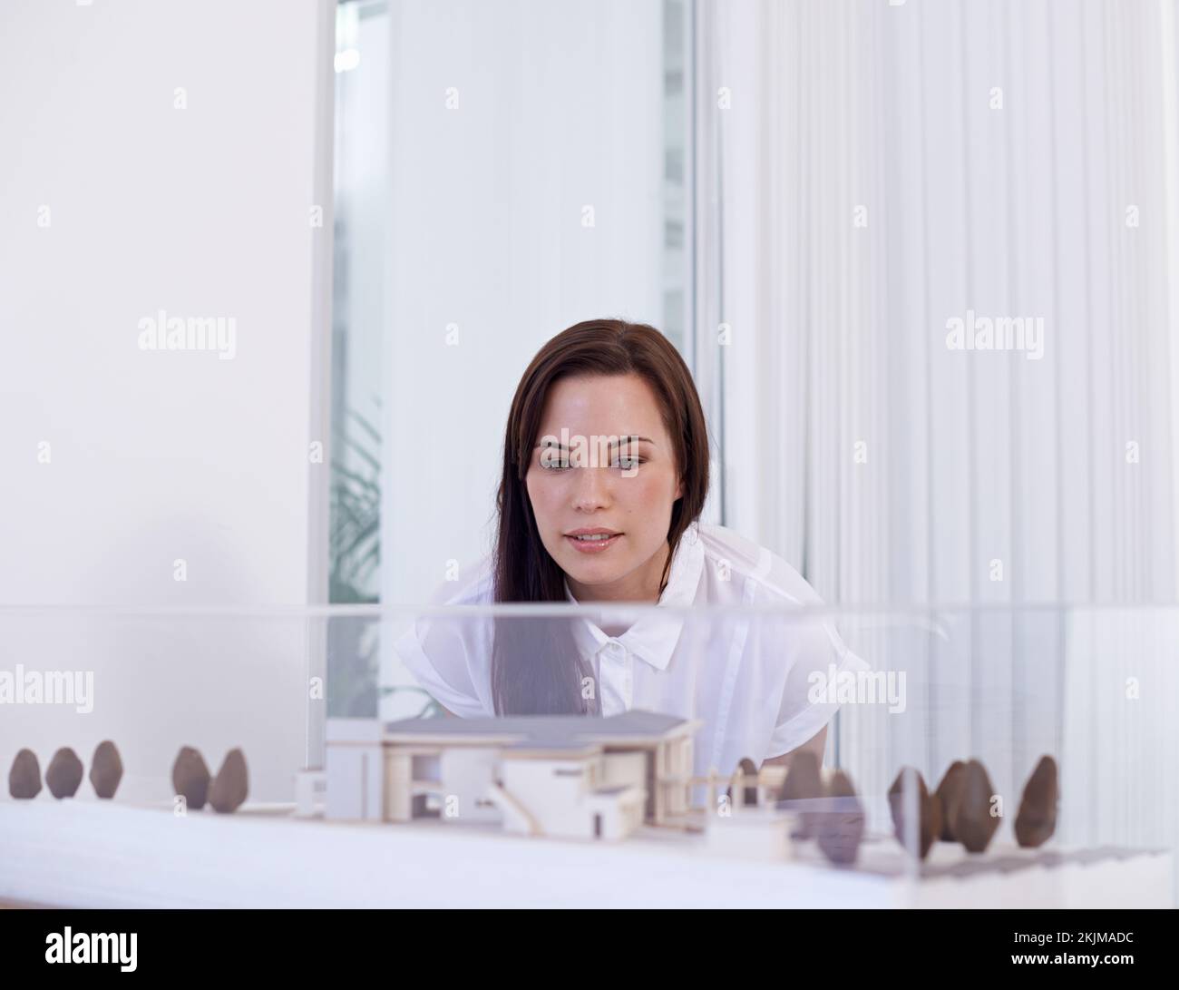 Tout doit être parfait. une jeune femme architecte attirante à la recherche d'un modèle à échelle. Banque D'Images