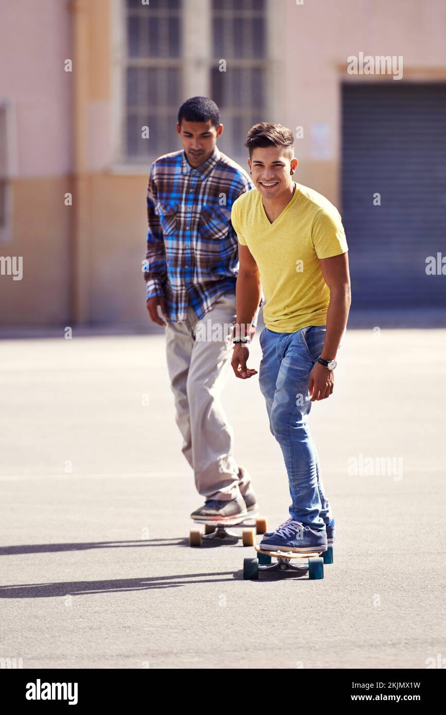 Ils nous voient rouler... deux jeunes hommes skate-board dans un parc de skate. Banque D'Images