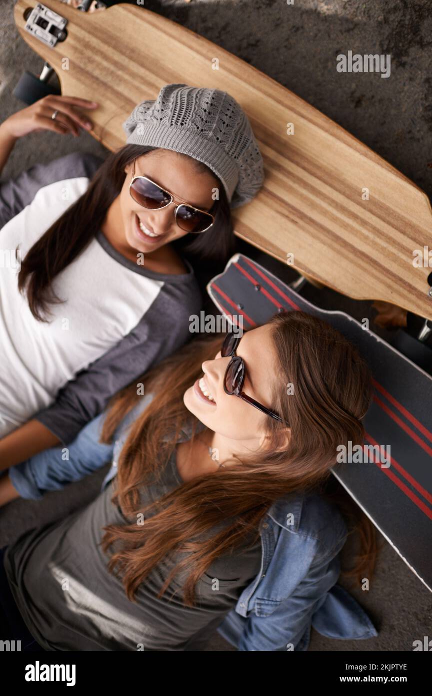 Se détendre ensemble au skate Park. deux jeunes femmes avec leurs planches à roulettes dans la ville. Banque D'Images