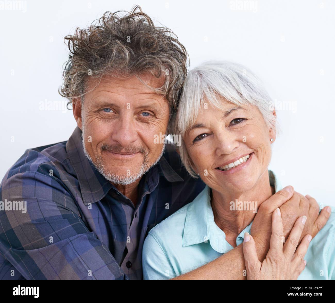 L'amour est fort avec ceux-ci. Portrait d'un couple aîné affectueux sur fond blanc. Banque D'Images