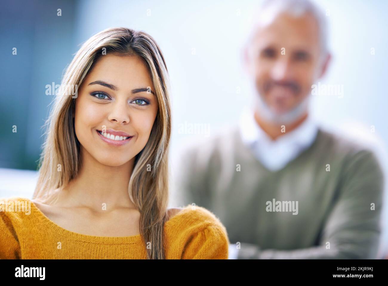 Le succès nous a fait sourire. Portrait d'une jeune femme d'affaires confiante avec son collègue debout derrière elle. Banque D'Images