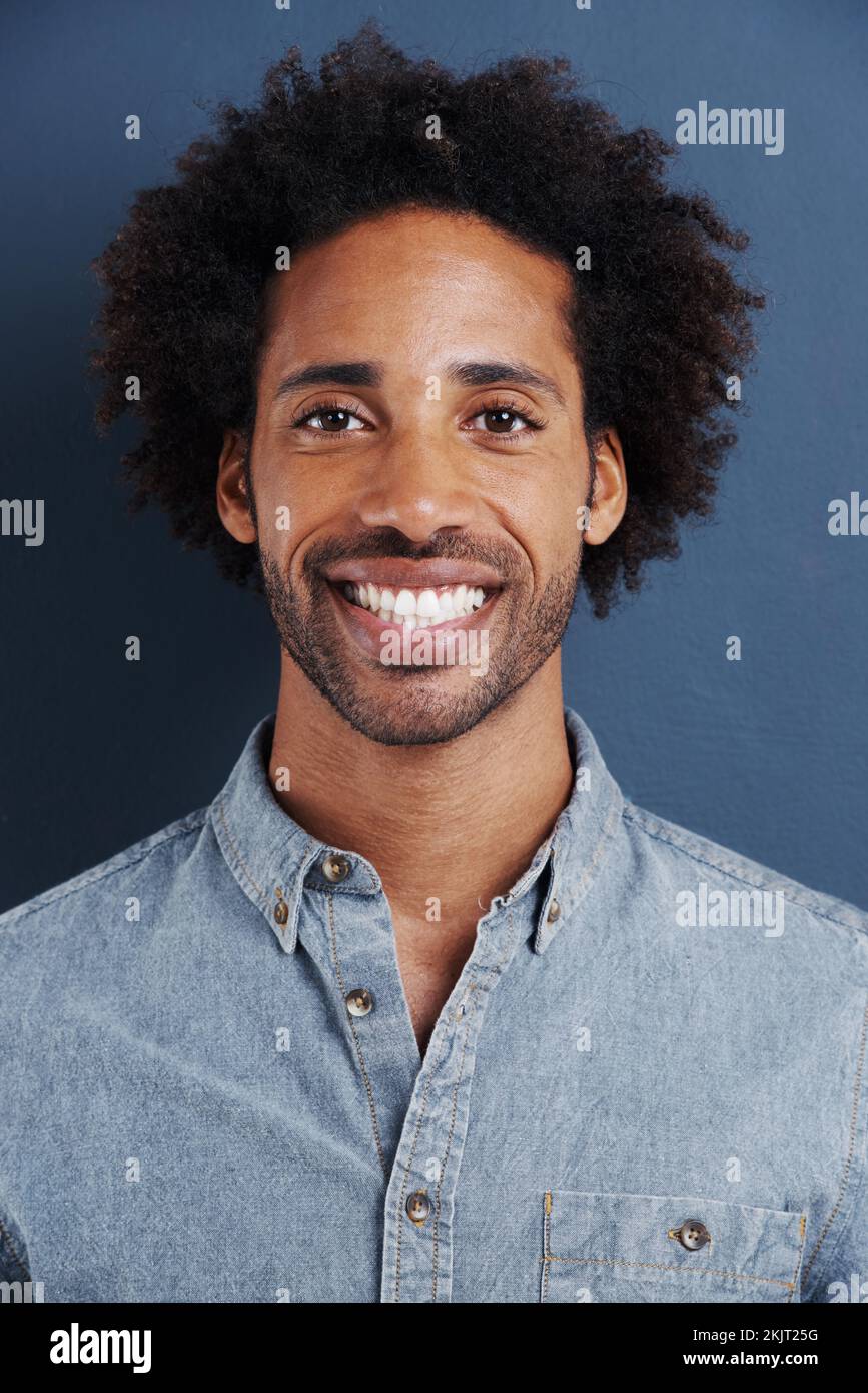 HES a reçu un sourire charmant. Portrait d'un beau jeune homme avec un grand sourire sur fond gris. Banque D'Images