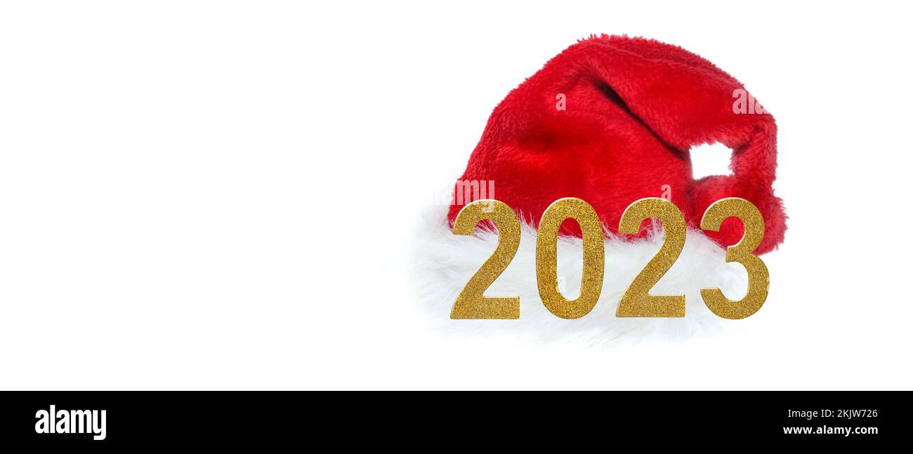 les numéros d'or de l'année 2023 devant le chapeau rouge du père noël sur fond blanc Banque D'Images