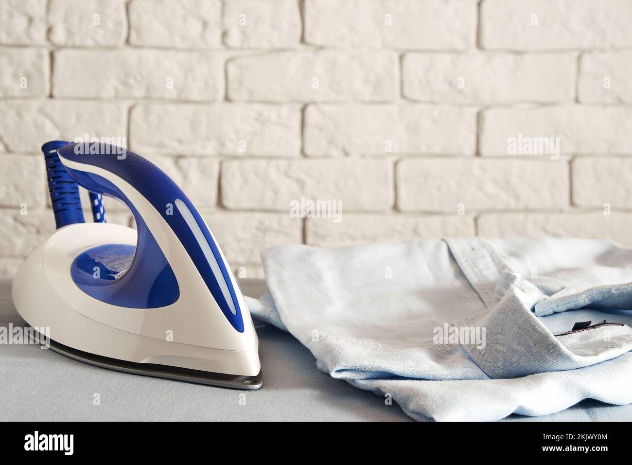 Fer électrique moderne et chemise pour hommes pliée sur la planche. Le travail à domicile et la lessive. Copier l'espace pour le texte Banque D'Images