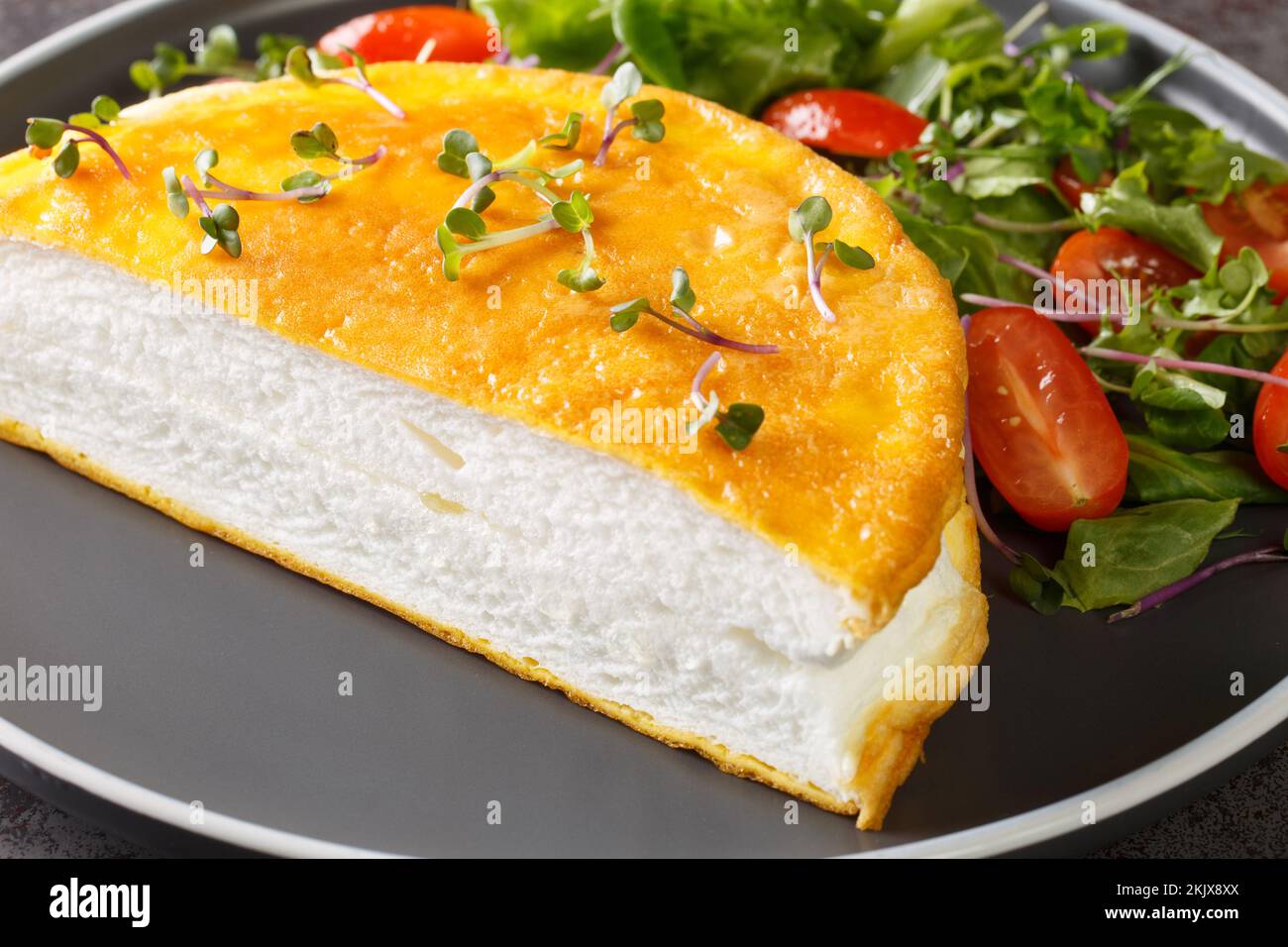 Œufs brouillés français omelette Poulard avec blancs fouettés sur l'assiette sur fond sombre. Horizontale Banque D'Images