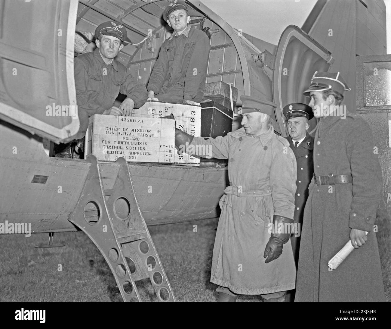 Les secours de déchargement fournis par l'UNRRA à Varsovie, en Pologne, en 1946. Les fournitures médicales transférées à partir d'un avion cargo comprennent une caisse contenant des médicaments pour lutter contre la tuberculose (tuberculose). L'UNRRA (Administration des Nations Unies pour les secours et la réhabilitation) était un organisme international de secours (de 1943 à 1948). L'agence a distribué environ $4 milliards de biens, de nourriture, de médicaments, d'outils et d'outils agricoles en période de graves pénuries et de difficultés de transport aux victimes de la guerre dans les zones sous le contrôle des Nations Unies – une photographie vintage de 1940s. Banque D'Images